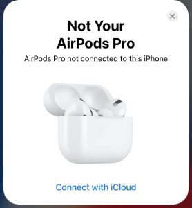 Same generation AirPods Pro charging in a same model matching case, iPhone displaying a "Not Your AirPods Pro" message but still functioning properly.